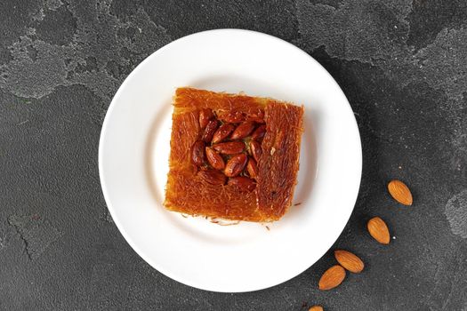 Turkish dessert baklava with nuts on black background, close up