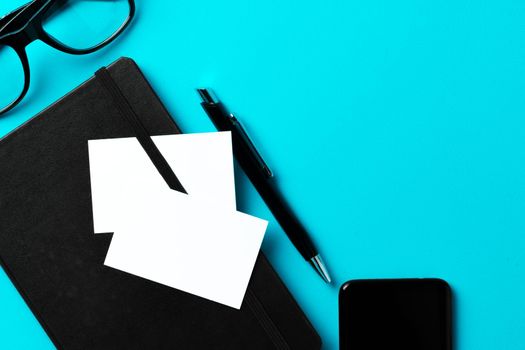 White businesscard with copy space on black notepad, close up
