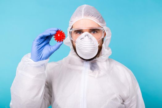 Covid-19, Vaccine development and medicine concept - Man scientist wears personal protective equipment and holding a model of coronavirus