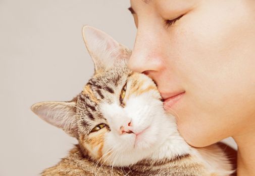 Happy woman is hugging orange tabby feline