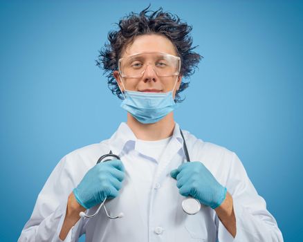 Crazy man doctor is holding stethoscope on a blue background