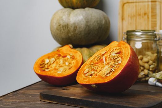 Pumpkin cut into halves on dark wooden table close up