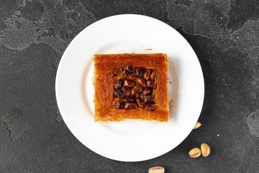 Turkish dessert baklava with nuts on black background, close up
