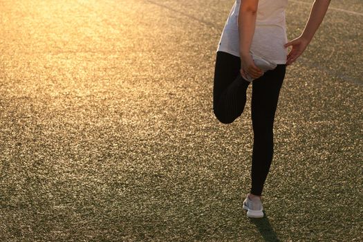 Sports girl doing stretching on the stadium lawn. High quality photo