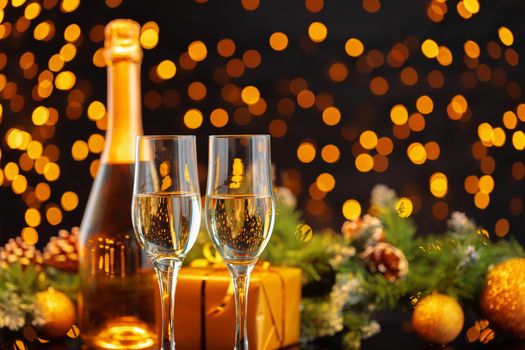 Champagne bottle and glasses on blurred lights background front view