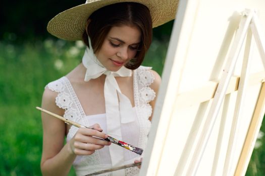 woman artist draws a picture on an easel outdoors. High quality photo