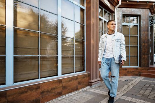 Portrait of handsome young casual man walking on the city street