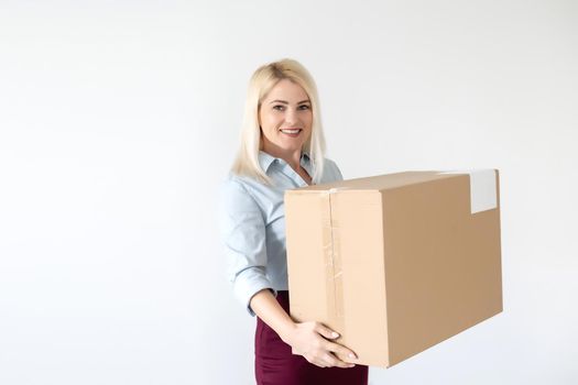 A young beautiful caucasian woman holding a box in her hands.