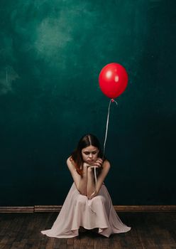 woman with red balloon on green background holiday fun. High quality photo