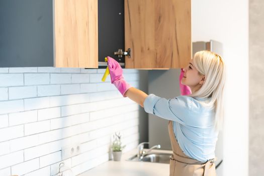 Young woman Cleaning Kitchen Cabinets