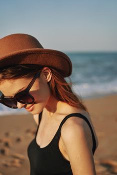 pretty woman in hat and sunglasses on the beach walk sun. High quality photo