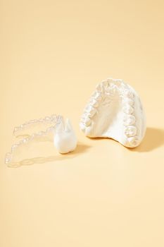 Orthodontic dental theme on  yellow background.Transparent invisible dental aligners or braces aplicable for an orthodontic dental treatment