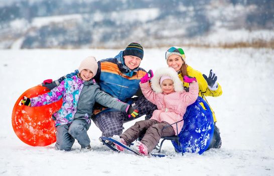Active happy family smiling and laughing while playing outdoors during winter holidays. Winter fun outdoors with children