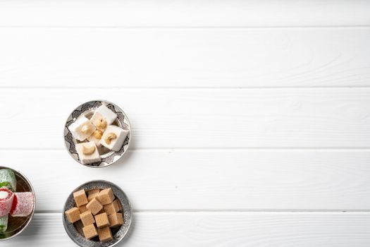 Top view photo of Turkish delight and brown cubed sugar in oriental dishware on table
