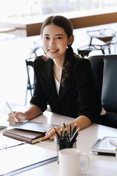 Company employees are sitting at work using tablet and documents in their work