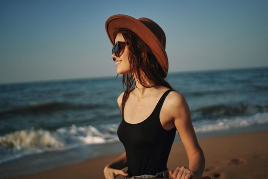 pretty woman in hat walking on the beach ocean travel. High quality photo