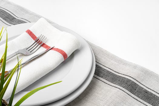 Fork, knife and plate on towel. Isolated on white background. Close up.