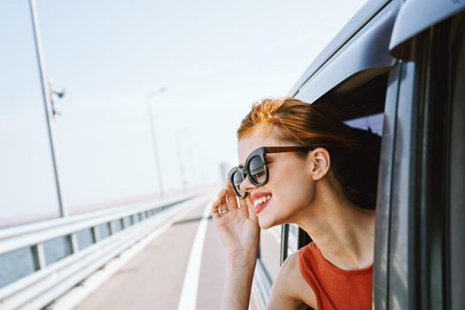 woman looking out of car window wearing sunglasses travel lifestyle. High quality photo