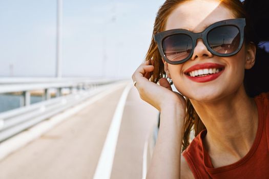 cheerful woman peeking out of the car window trip adventure lifestyle. High quality photo