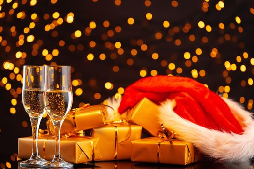 Champagne and Santa Claus hat on blurred garland background front view