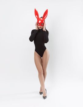 the woman in red rabbit mask and black bodysuit on white background