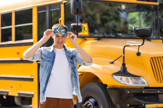 Portrait of smiling teacher near school bus