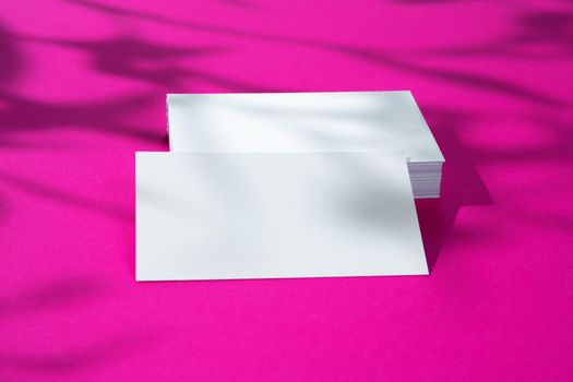 Advertising mock-up. White blank businesscards on bright pink background. copy space