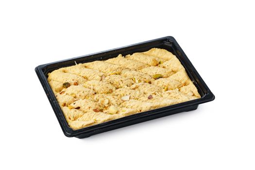 Black plastic box of Turkish halva dessert isolated on white background