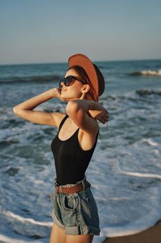 woman walking on the beach hat travel vacation sun. High quality photo