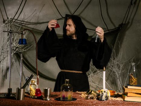 Portrait of a medieval scientist working in his laboratory. Alchemist. Halloween concept.