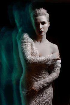 Beautiful girl in white lace negligee. A trace from a mixed light. The Snow Queen. Low key