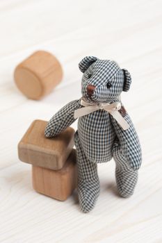 Cute teddy bear on wooden background with wooden baby toys