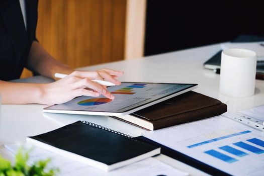 Business owners are using a computer tablet. in managing financial statements to adjust the company's financial structure