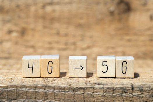 Wooden cubes From 4g To 5g with black arrow pointing On wooden background, mobile or technology concept closeup