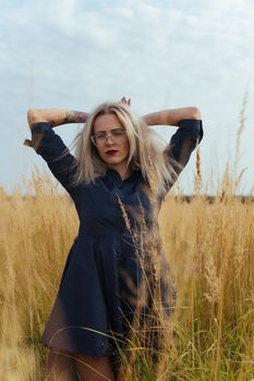 Beautiful girl villager posing in a dress in the field