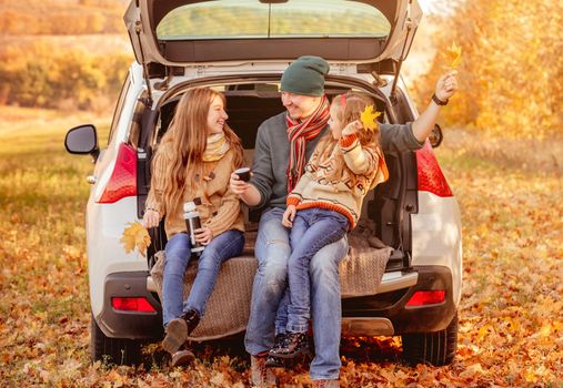 Smiling father with daughters in autumn surroundings