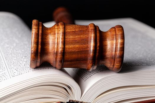 Wooden gavel and juridical books close up