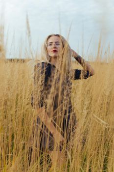 Beautiful girl villager posing in a dress in the field