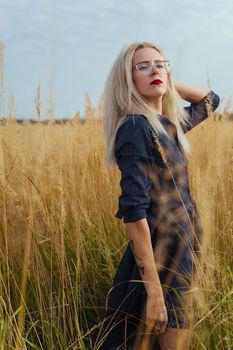 Beautiful girl villager posing in a dress in the field