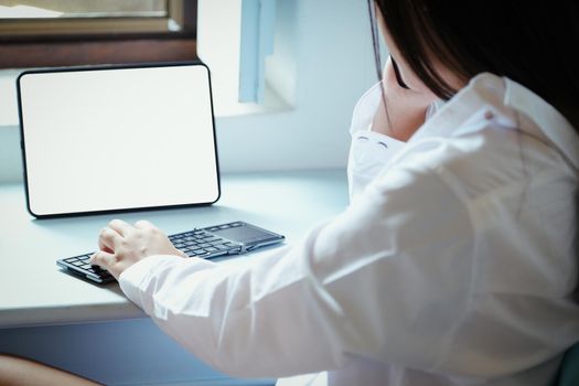 The new normal. A businesswoman is using computer and phone to work for a company. over the Internet on your desk at home
