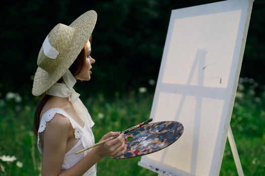 Woman in white dress artist easel painting nature landscape. High quality photo