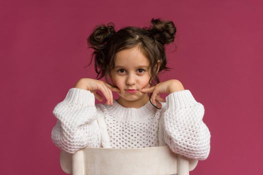 Photo of smiling little girl child isolated over pink background. Looking camera.