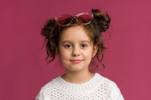 Photo of smiling little girl child isolated over pink background. Looking camera.