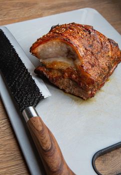 Grilled marinated Pork Belly barbecue with cutting knife and cutting board, closeup