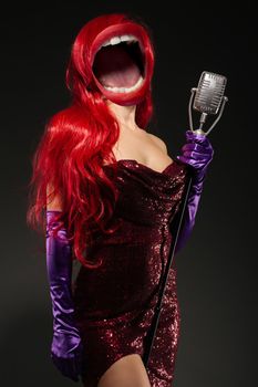 Collage of open mouth instead of a woman's head with very long hair in red gown with microphone on the stand on a black background. Sexy gown on a beautiful slim figure. Long pink gloves
