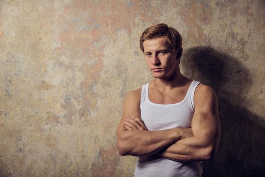 Beautiful gay in white t-shirt posing against grunge background