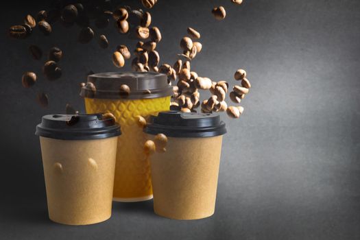 Coffee paper cups with coffee beans on a dark background. Pattern and creative background concept for cafes