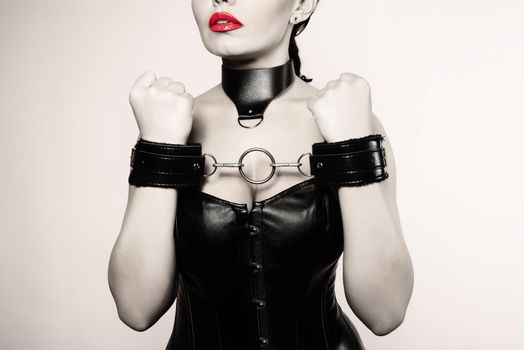 Submissive girl in leather black corset, handcuffs and collar waiting for punishment. - Blsck and white Image