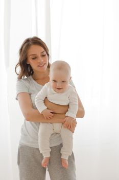 Cheerful woman playing with adorable infant child.