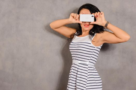 girl photographed on a mobile phone on a gray background